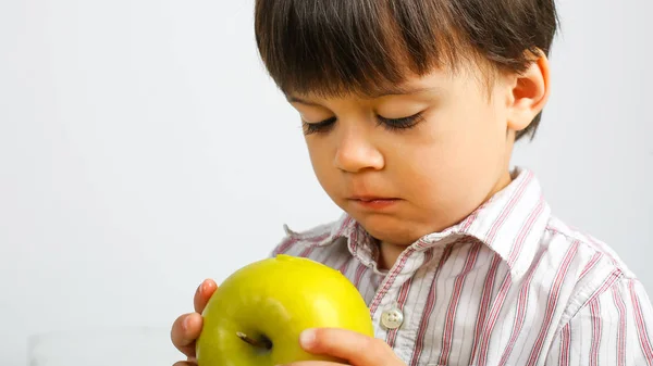 pretty small boy eating green apple