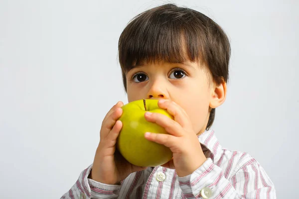 pretty small boy eating green apple