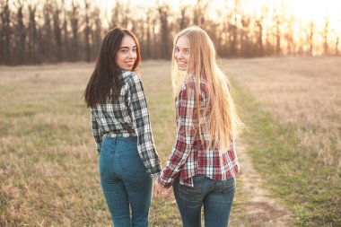 Sahada akşam yürüyüş iki neşeli genç kadın. En iyi dostlar