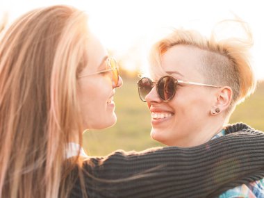 İki genç kadın açık havada günbatımında sarılma. Yakın çekim