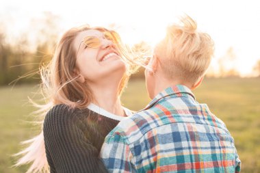 Açık havada günbatımında sarılma iki genç kadın