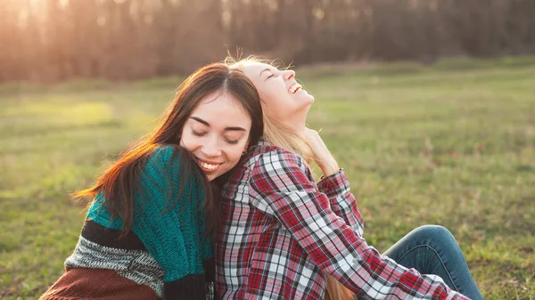 Duas Jovens Sentadas Relva Abraçadas Melhores Amigos — Fotografia de Stock