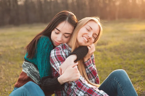 Dvě Mladé Veselé Ženy Sedí Trávě Objímání Nejlepší Kamarádi — Stock fotografie