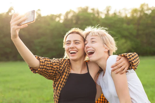 两个开朗的年轻女性在手机上做自拍 — 图库照片
