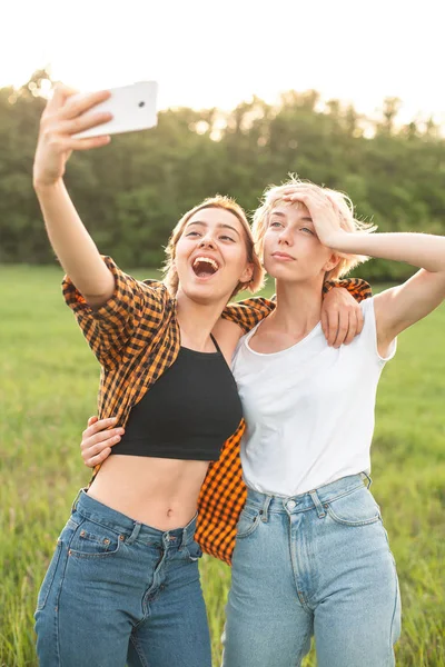 Δύο Χαρούμενα Νεαρών Γυναικών Κάνοντας Αυτοπροσωπογραφίες Για Κινητό Τηλέφωνο Εξωτερικούς — Φωτογραφία Αρχείου