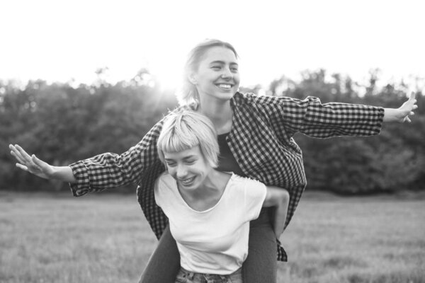 Две красивые молодые женщины веселятся на открытом воздухе. Лучшие друзья
