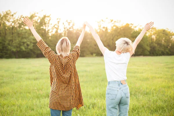 Δύο Γυναίκες Σηκώνουν Χέρια Τους Επάνω Στο Πεδίο Καταπράσινη Καλύτεροι — Φωτογραφία Αρχείου