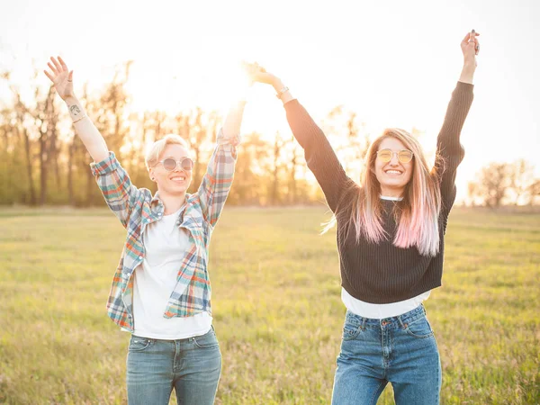 Duas Jovens Mulheres Campo Pôr Sol Levantar Mãos — Fotografia de Stock