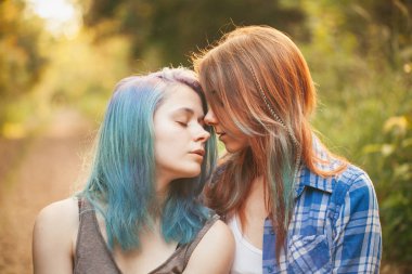 İki güzel genç kadın güneş ışığı altında ormandaki dinlen. Sıcak renkler