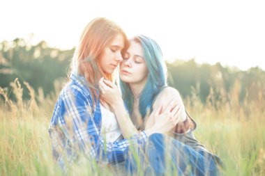 Çimenlerin üzerinde oturan iki güzel kız.