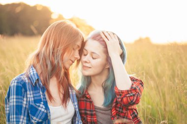 İki güzel genç kadın çimlerde oturuyor. En iyi dostlar