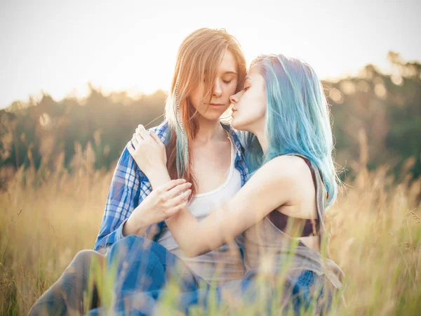 两个温柔的年轻女人坐在草地上 — 图库照片