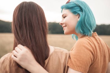 İki genç arkadaş sahada sarılma gülümseyen