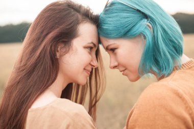 İki genç arkadaş sahada sarılma gülümseyen