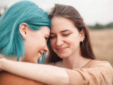 İki genç arkadaş sahada sarılma gülümseyen