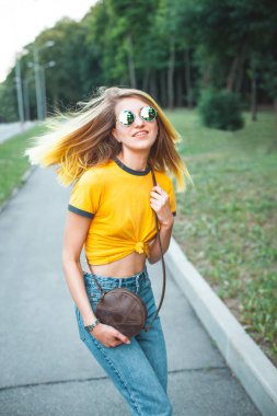 Parkta yürüyen genç şık neşeli kadın 