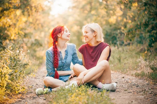 Δύο Νεαρές Γυναίκες Κάθονται Στο Δρόμο Στο Δάσος Και Γέλιο — Φωτογραφία Αρχείου