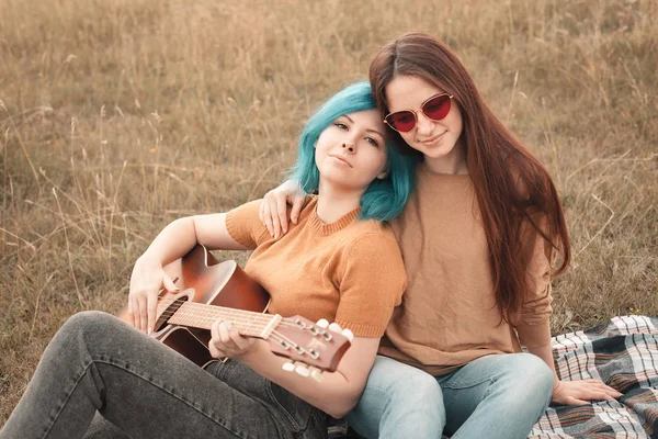 Dos Mujeres Jóvenes Yacen Campo Tocan Guitarra —  Fotos de Stock