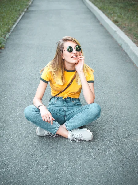 Νεαρή Γυναίκα Γυαλιά Ηλίου Που Κάθεται Στο Δρόμο Στο Πάρκο — Φωτογραφία Αρχείου