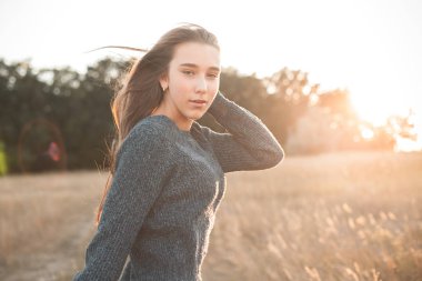 Güneş ışığı altında açık havada yürüyen aktif genç kadın