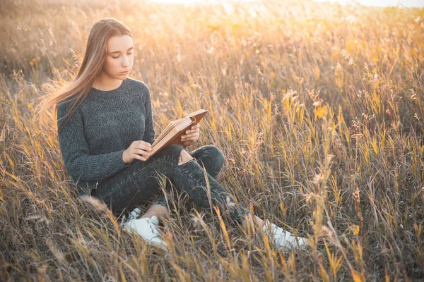 Młoda Kobieta Czytając Książkę Zewnątrz Zachodzie Słońca — Zdjęcie stockowe