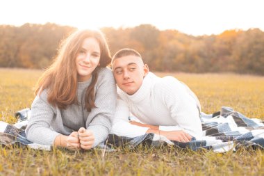 Genç adam ve kadın çim üzerinde yalan