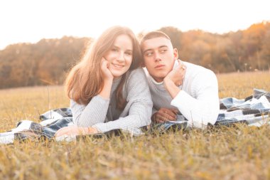 Genç adam ve kadın güneş ışığı altında çim üzerinde yalan