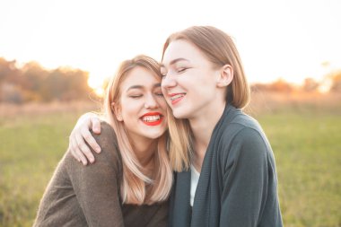 İki neşeli genç kadın zaman birlikte ve sarılma açık havada harcamak. En iyi dostlar