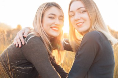 Günbatımı sahasının iki neşeli genç kadın. Yakın çekim