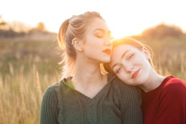 Sahada günbatımında iki neşeli genç kadının.... En iyi dostlar
