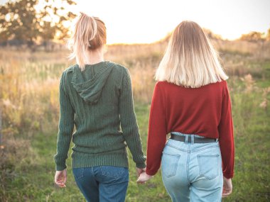 Açık havada yürüyüş günbatımında iki genç kadın. Arkadan görünüm