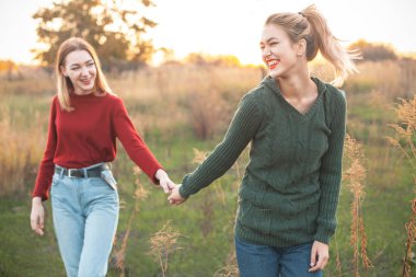 Açık havada yürüyüş günbatımında iki neşeli genç kadın. En iyi dostlar