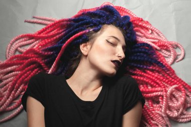 Garip saçlı güzel genç kadın yerde yatıyor