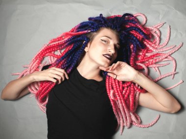 Güzel genç kadın, sıradışı saç kesimi yerde yatıyor