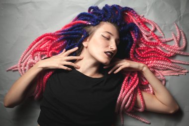 Sıradışı saç kesimi olan tutkulu kadın yerde yatıyor