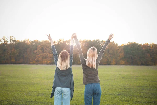 Twee Jonge Vrouwen Permanent Groene Veld Opkomst Handen — Stockfoto