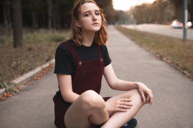 Akşam saatlerinde yola oturan genç kadın