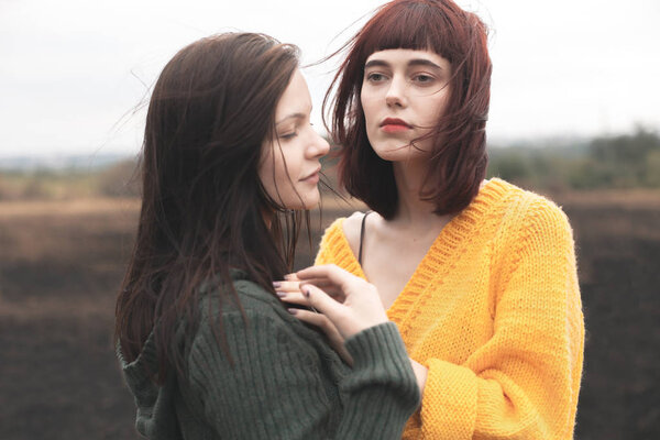 Two woman are walking outdoors and hugging