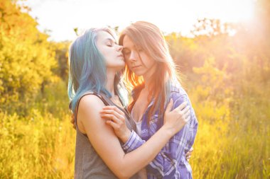 İki kız güneş ışığında ormanda eğlenmek