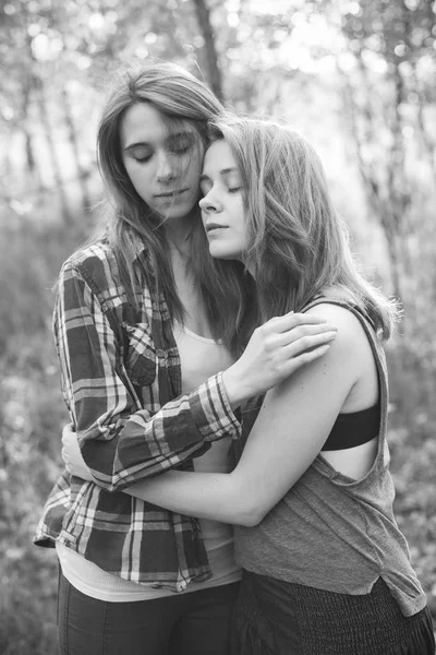 两个年轻女子在户外拥抱 黑色和白色 — 图库照片