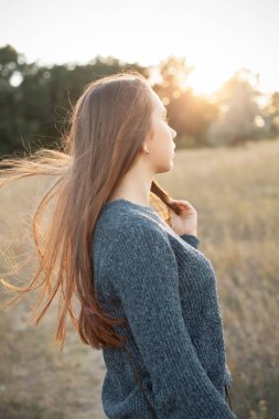 Gün batımında açık havada Genç kadın portresi. Geri