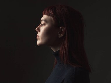 Stüdyodan çekici genç kadın. Profil.