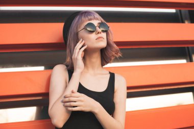 Turuncu şeritler arka planda yakın genç kadın ayakta