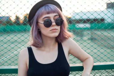 Çitin yakınında duran şık genç kadın