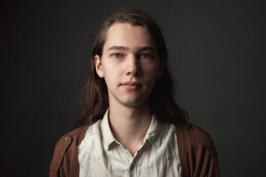 Uzun saçlı yakışıklı genç adam gülümseyen