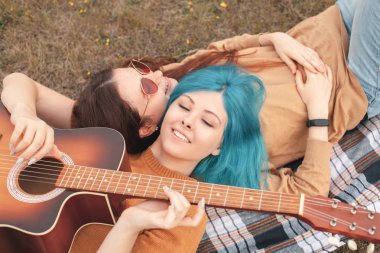 İki kadın yalan söylüyor ve gitar çalıyor. En iyi dostlar