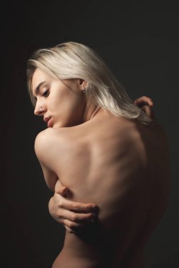 Siyah arka planda güzel genç kadın topless