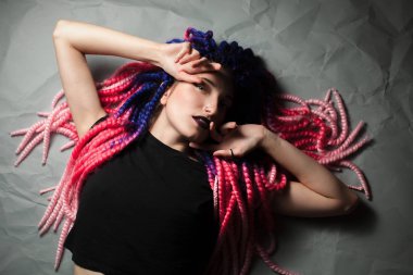 Sıradışı saç kesimi olan güzel kadın yerde yatıyor