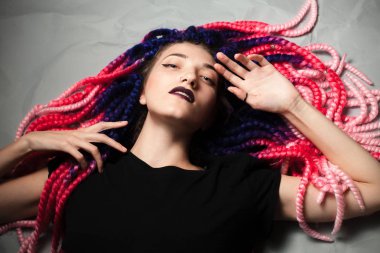 Garip saçlı güzel genç kadın yerde yatıyor