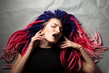 Sıradışı saç kesimi olan tutkulu kadın yerde yatıyor